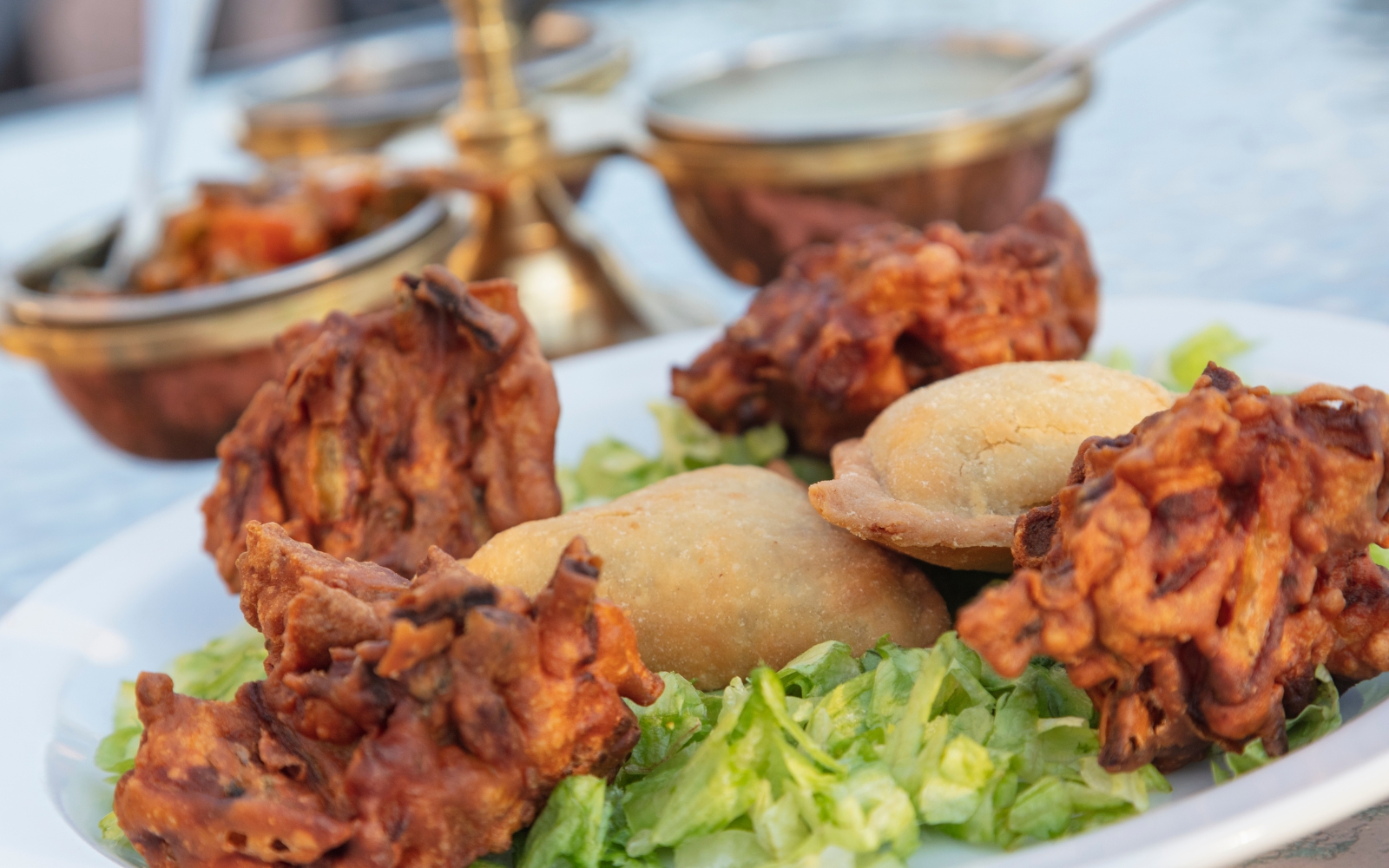 A vibrant platter of Indian starters with samosas, pakoras, and chutneys, perfect for sharing at Uxb